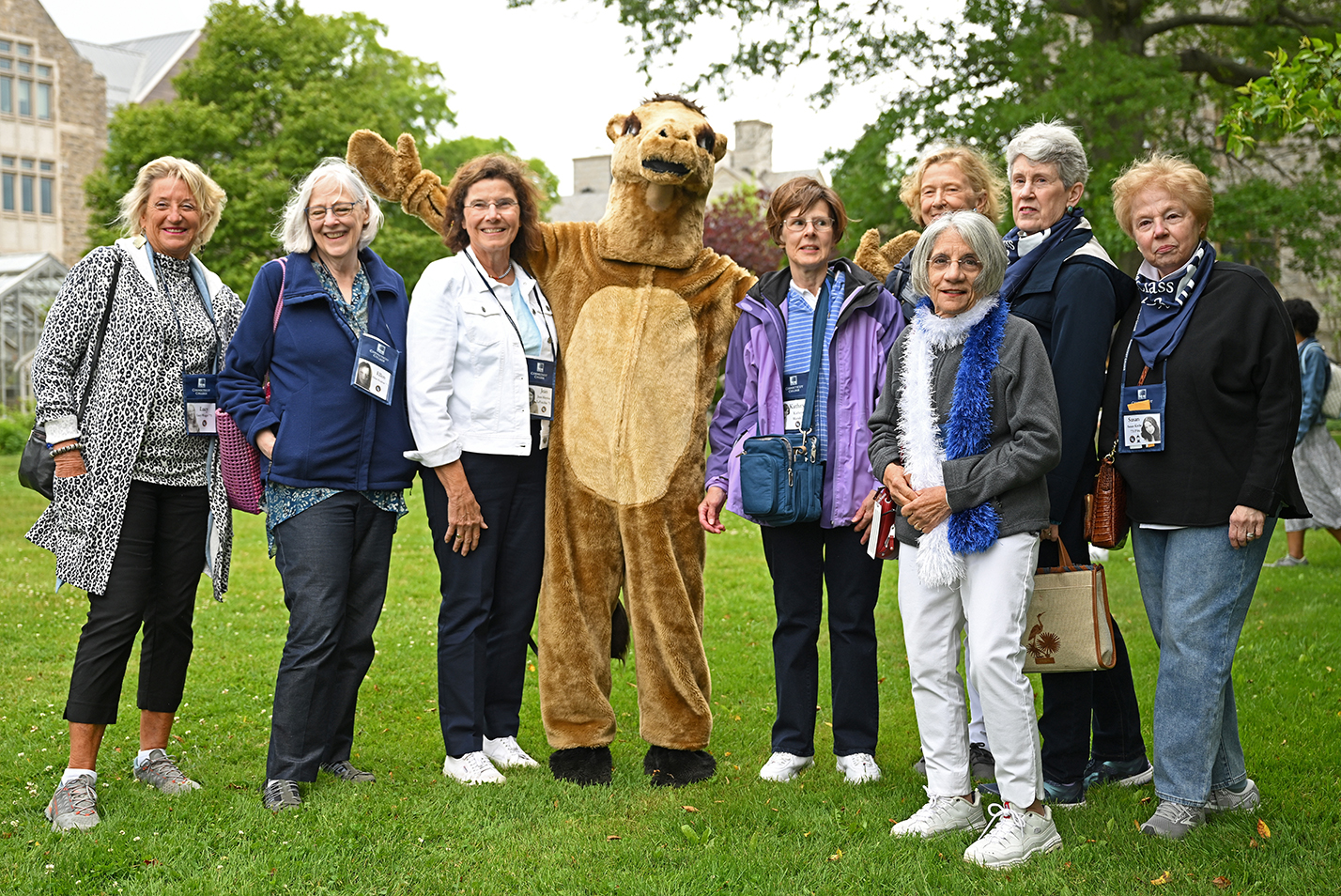 A group of alumni pose with the camel