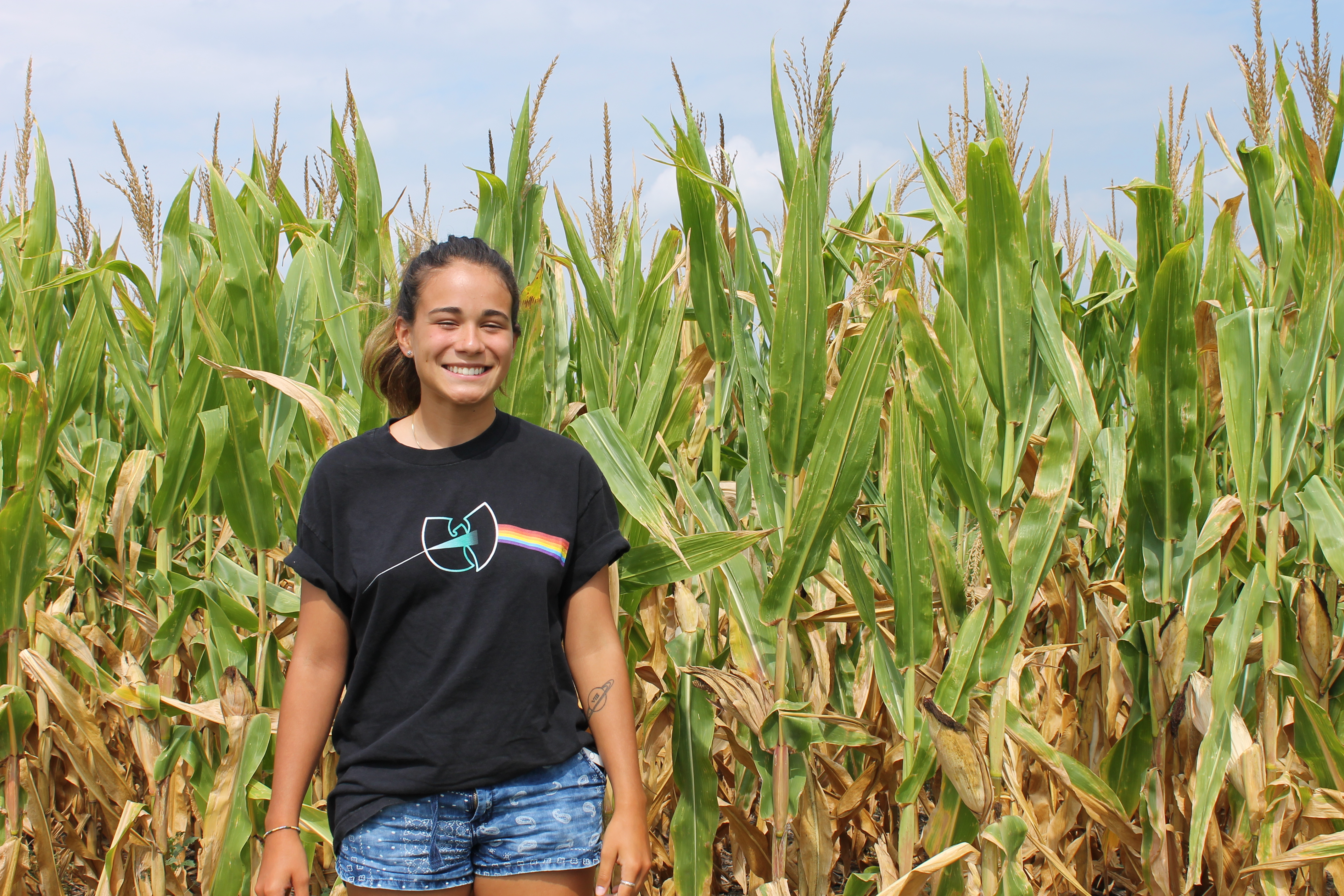 Dani posing in front of miles of corn fields. 