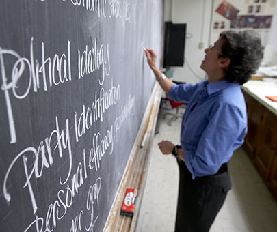 MaryAnne Borrelli, professor of government, writes on the board during a lecture.