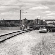 Winthrop Cove, 1979. An abandoned car and boat are beside train tracks.