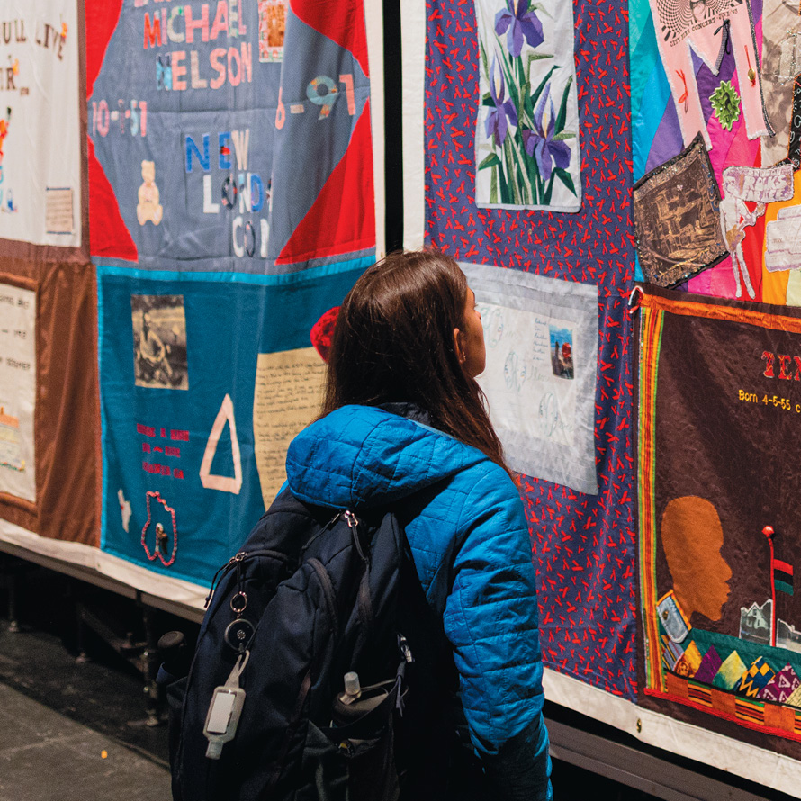 Image of student looking at AIDS quilt