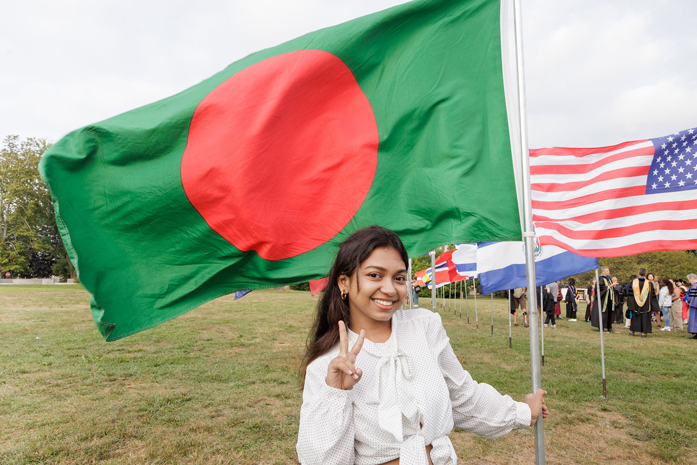 A student poses with one of the flags on the green.