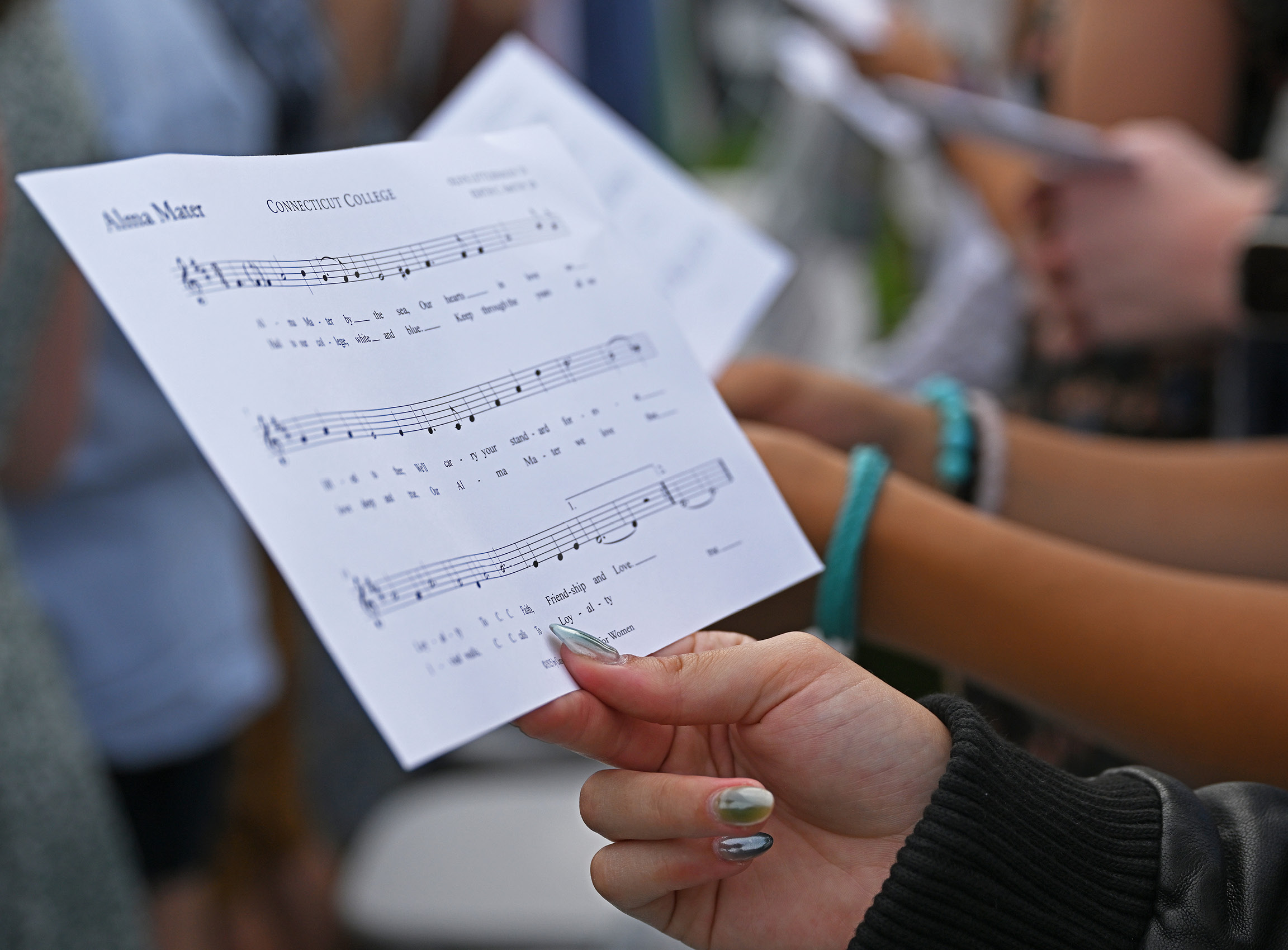 Close-up of student holding the Alma Mater sheet music