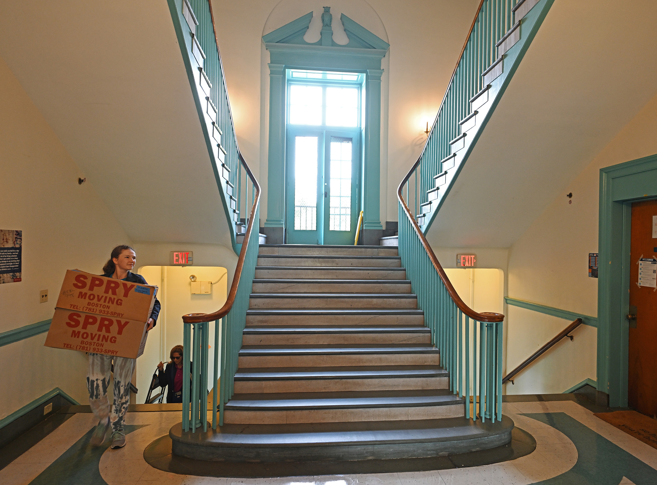 A parent moves boxes up a staircase in one of the College's dorms.