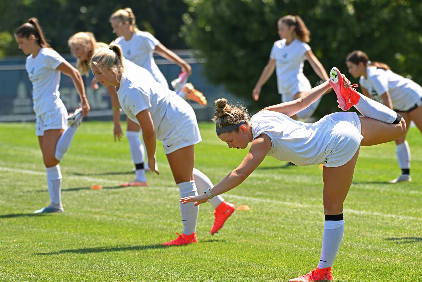 Women's soccer players warming up on the Green.