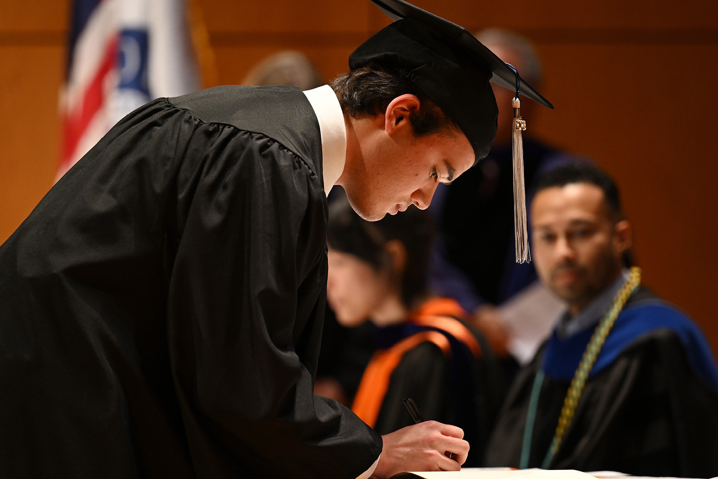 A student signs the PBK registry at a ceremony prior to Commencement