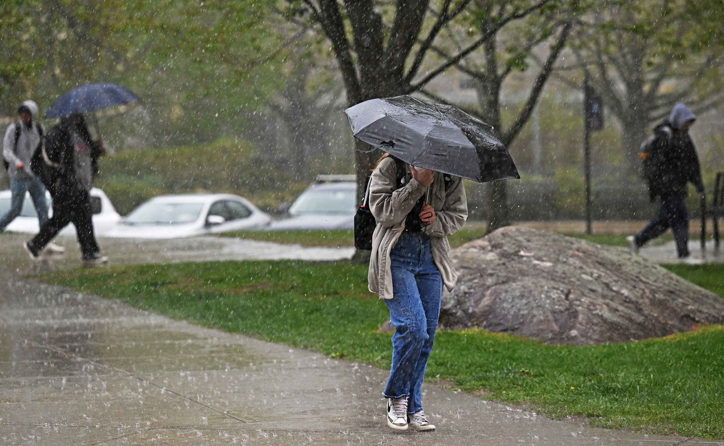 Student walks through the rain in May