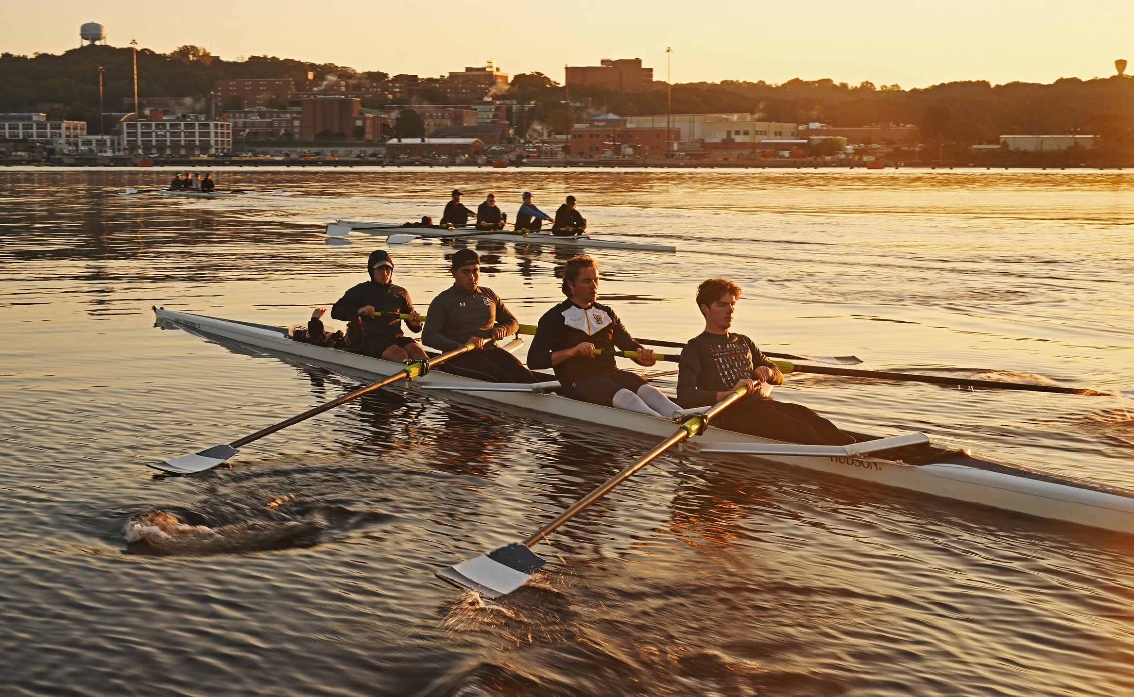 Men's crew rows on the Thames River at dawn in October.