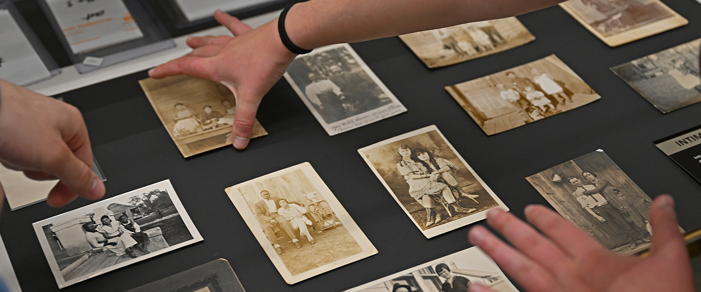 Students arrange photographs in a display case Nov. 7