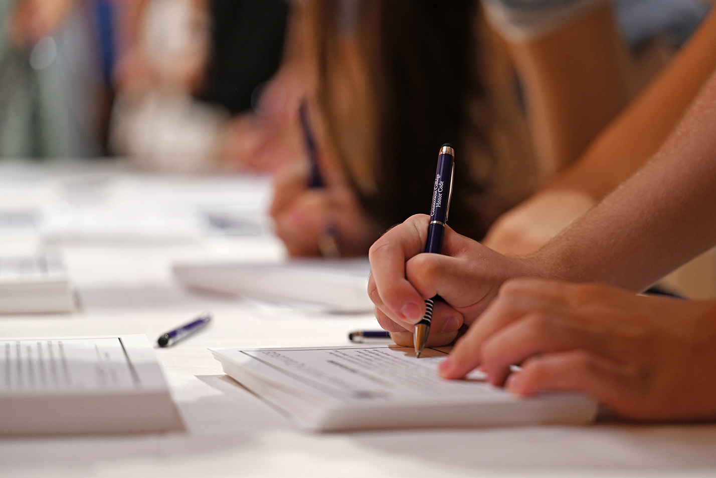 Close up view of students signing honor code documents