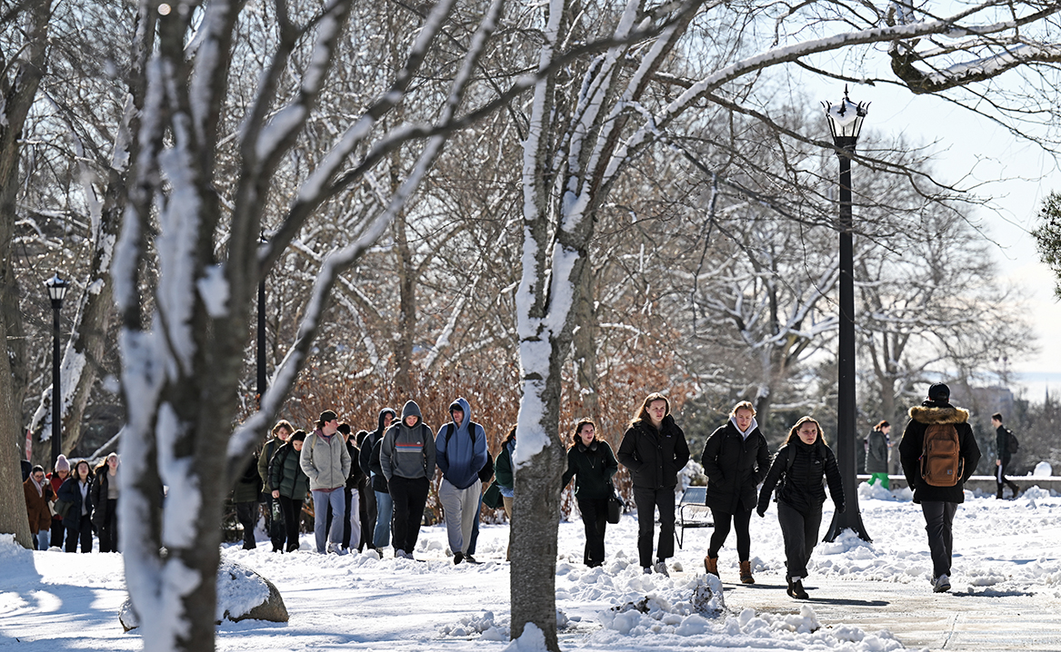 Students walk across a snow-blanketed campus