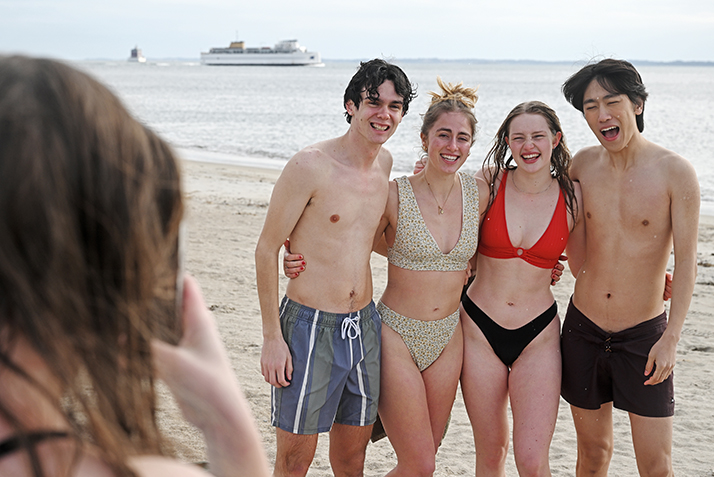 students pose for a photo on the beach