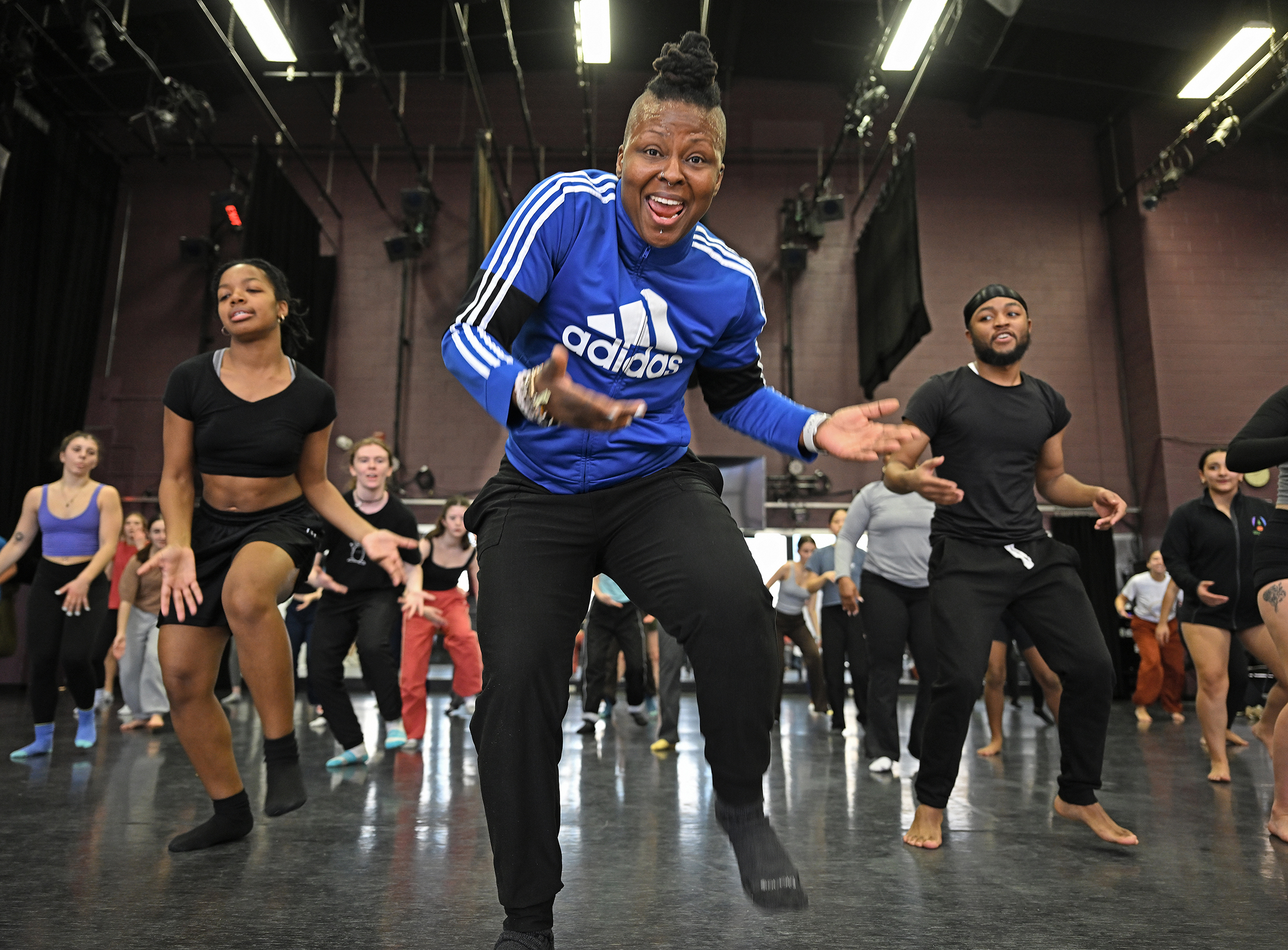 Dance instructor leads class in crowded studio