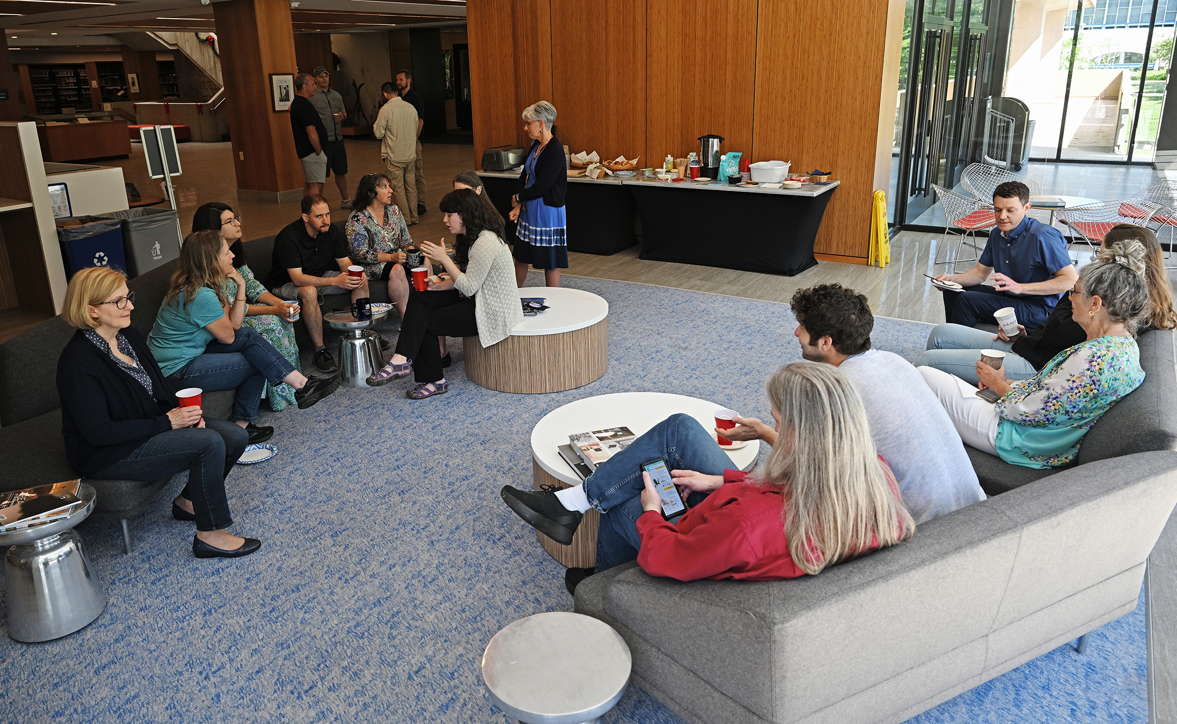 A group of people sit around and socialize in a library common room