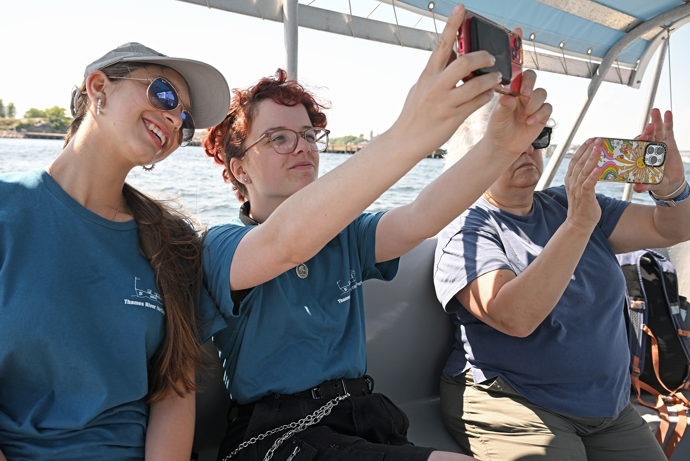 two students take a photo together while riding in a boat.
