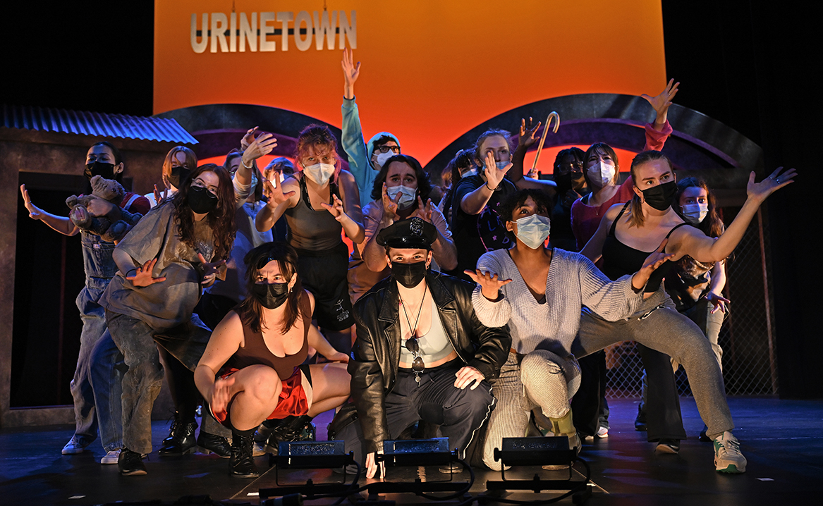 The cast of Urinetown performs during a tech rehearsal.