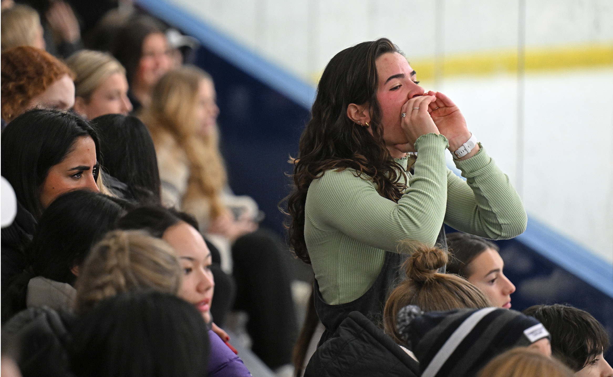 A female fan cheers on men's hockey at Dayton Arena.