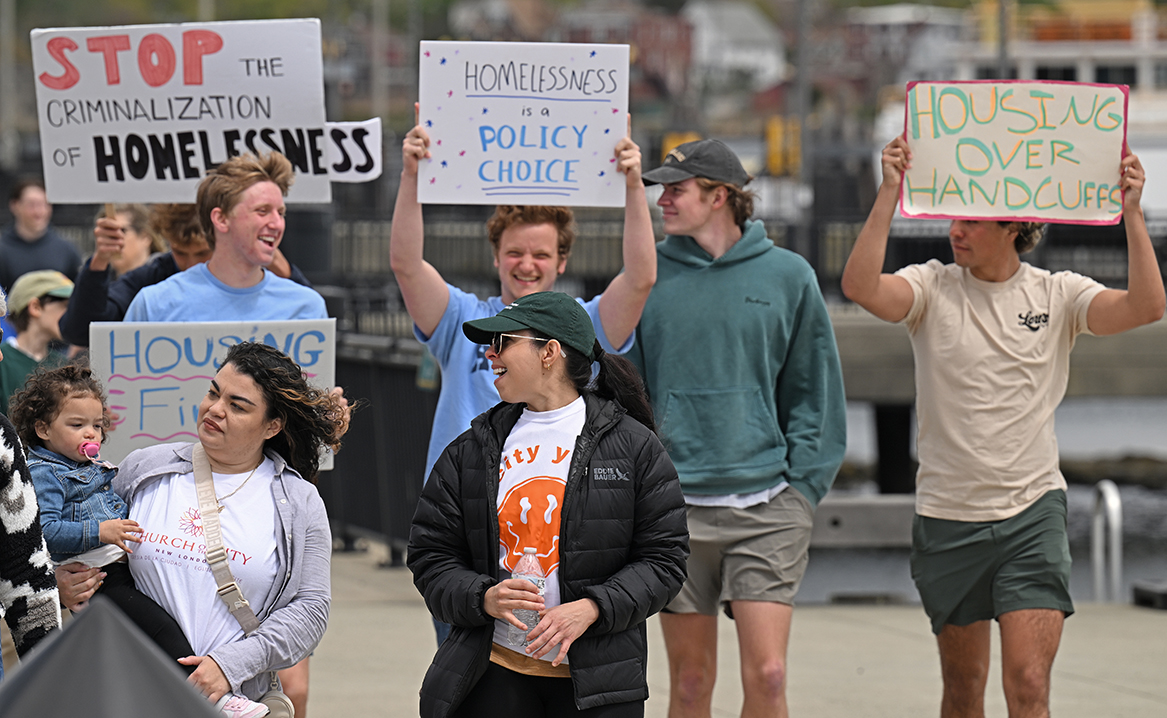 Students carry signs while participating in the Walk to End Homelessness