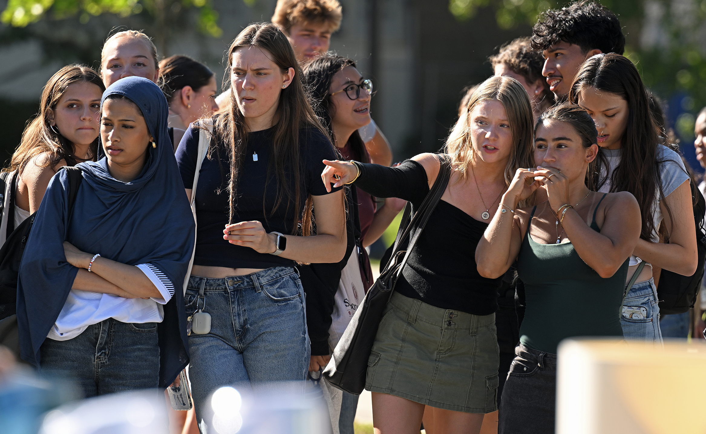 College students look and point as they size up the offerings at a campus yard sale event.