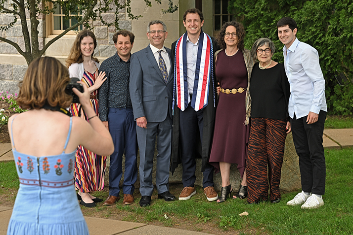 A graduate poses with members of their family.