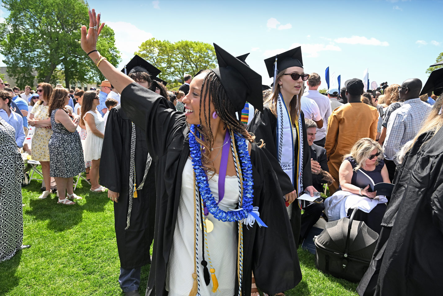 A graduate waves to the crowd.