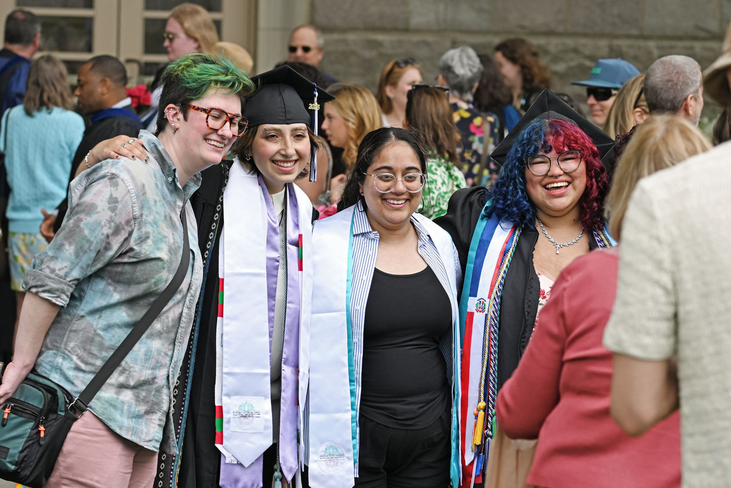 A graduate poses for photos with friends and family.