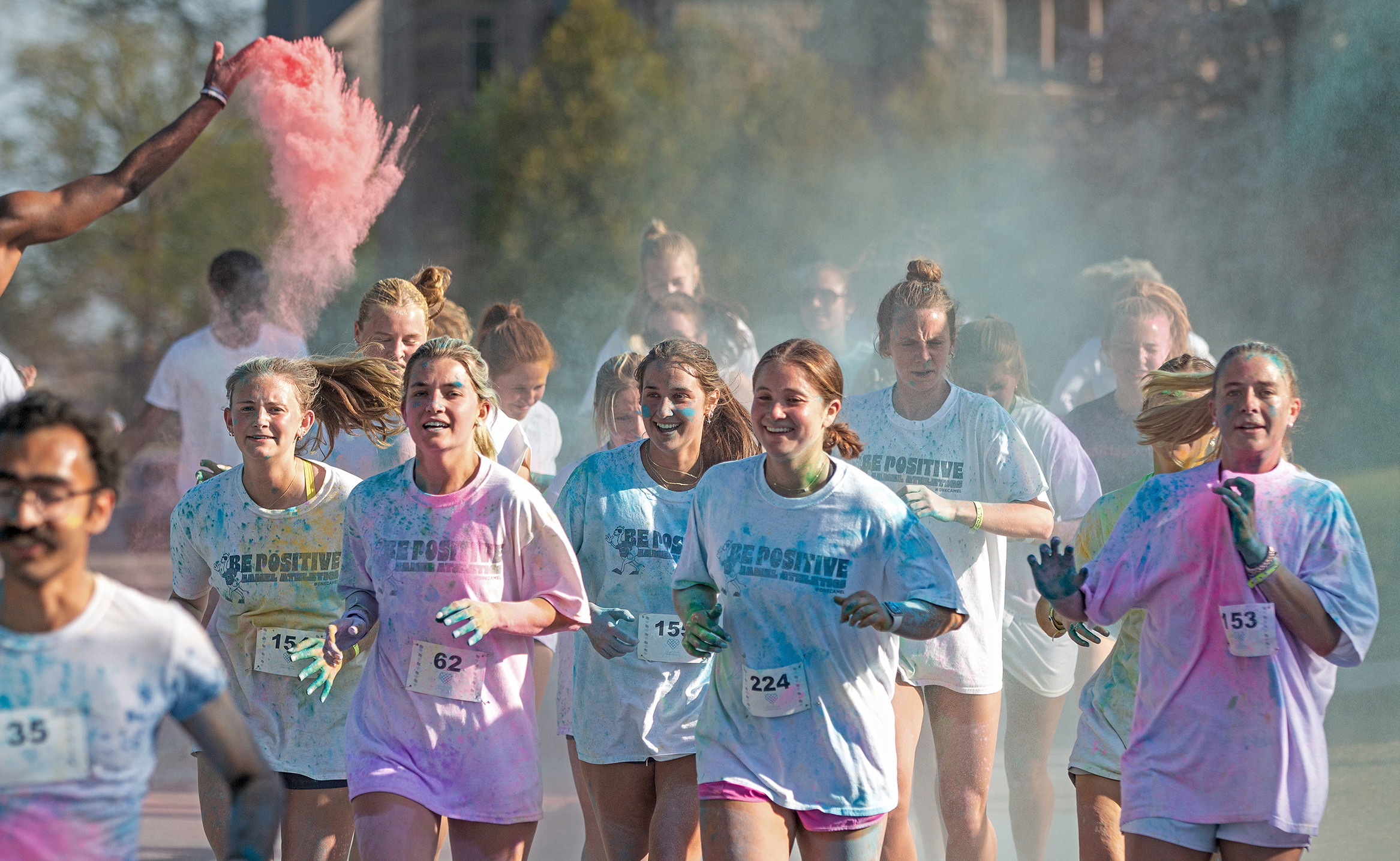Students run through a cloud of colorful chalk during a Color Run.