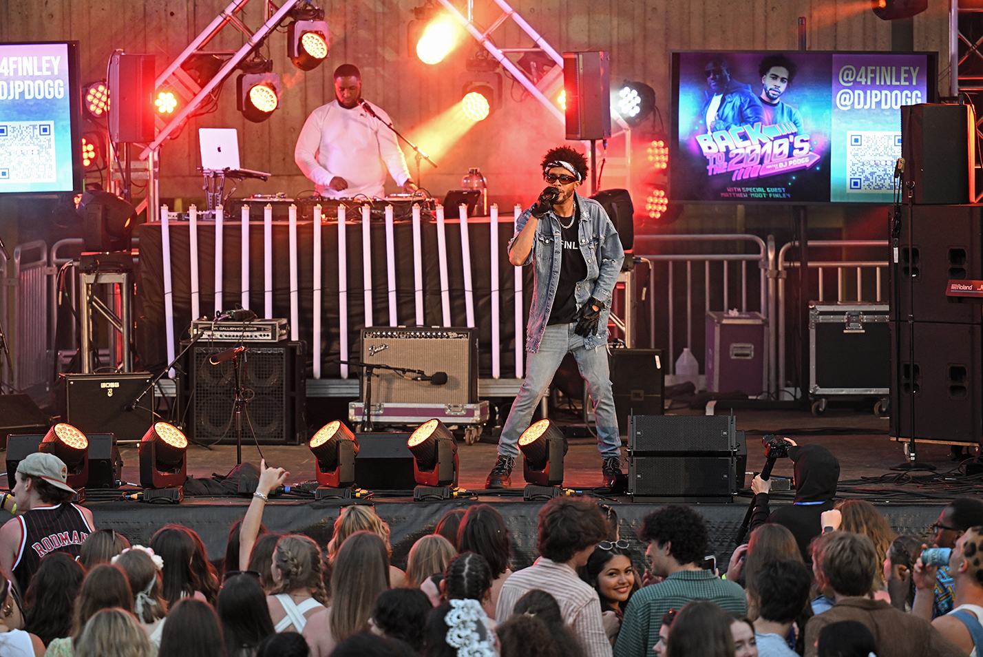 A rap artist performs on stage during a college music festival.