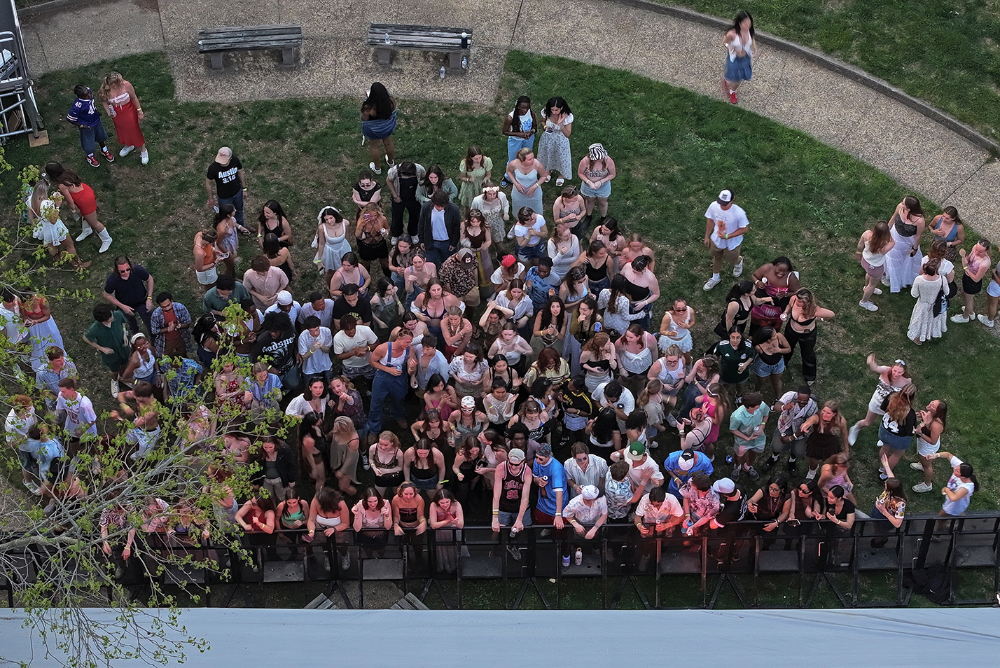 A crowd of students is seen from overhead as they gather at the stage during an outdoor music festival.