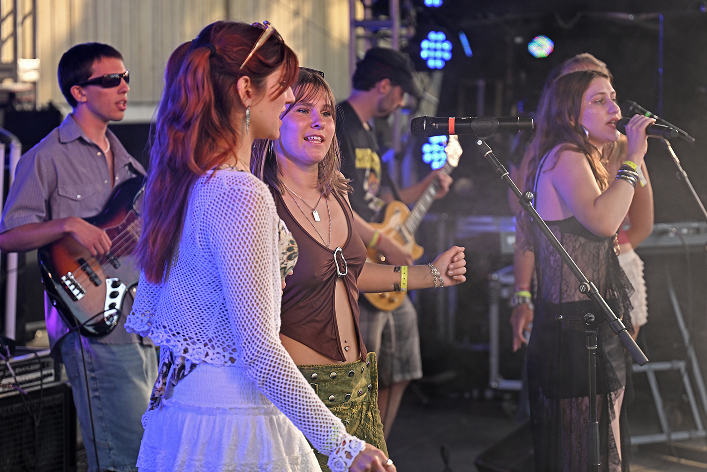 A student band performs onstage during an outdoor music festival.