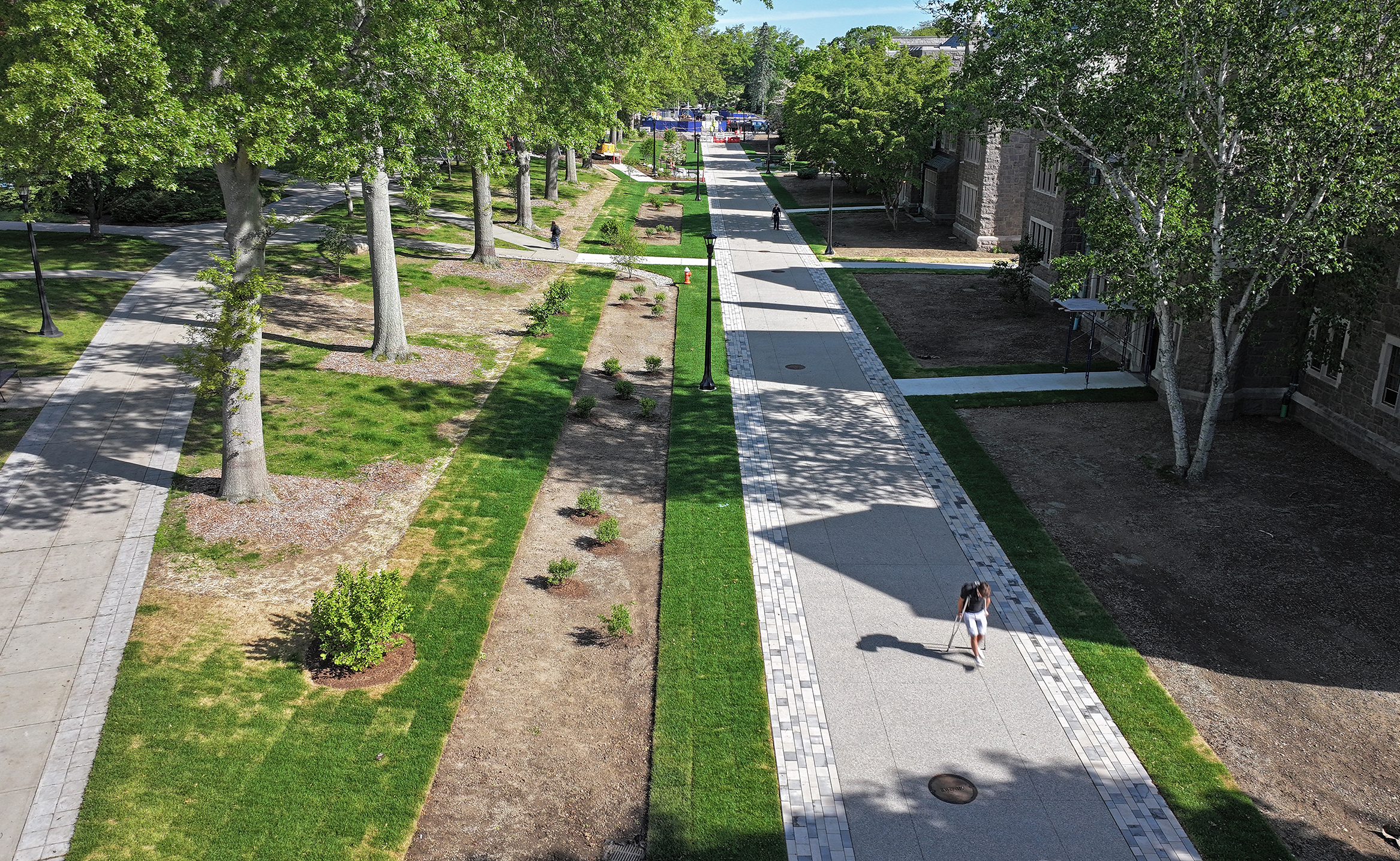 A student makes their way along a newly finished pedestrian promenade through campus.