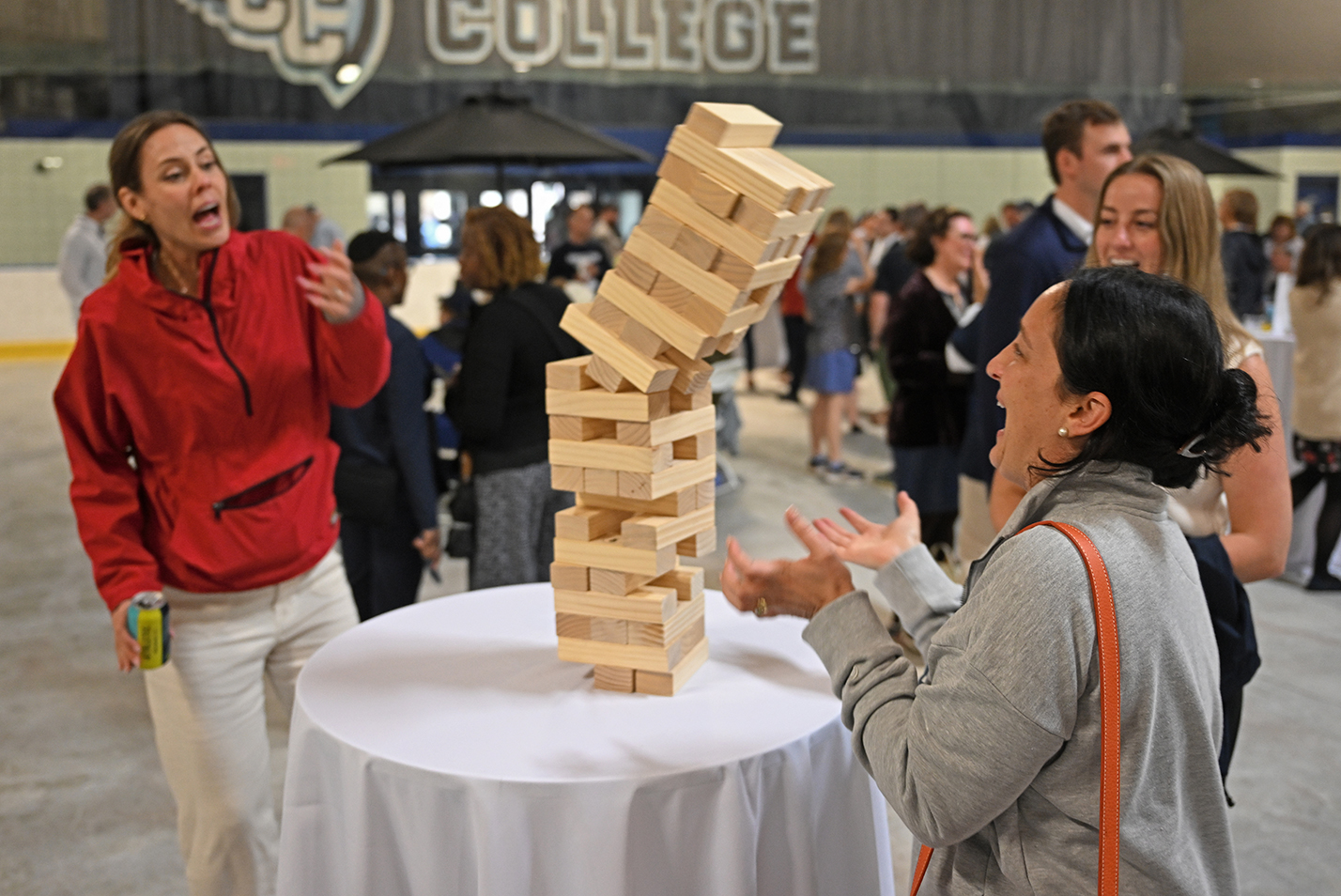 College alumni play a tower tumble wood block game during their reunion weekend.