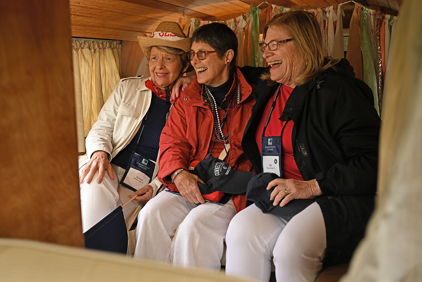Three college alumni gather in photo booth.