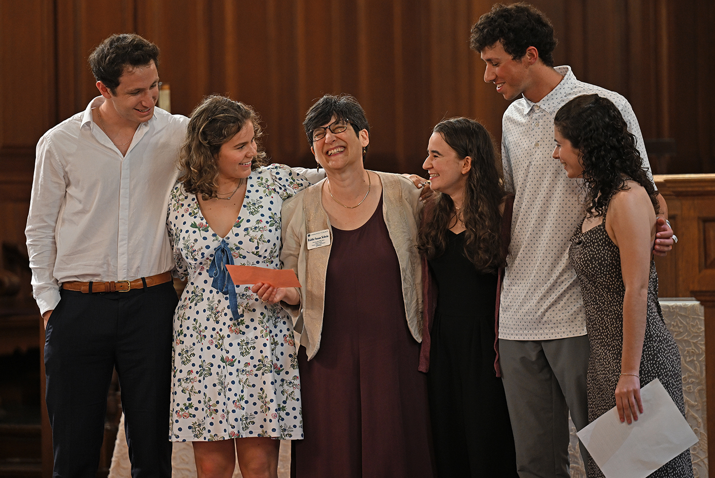 Students gather around their retiring Rabbi during a college baccalaureate ceremony.