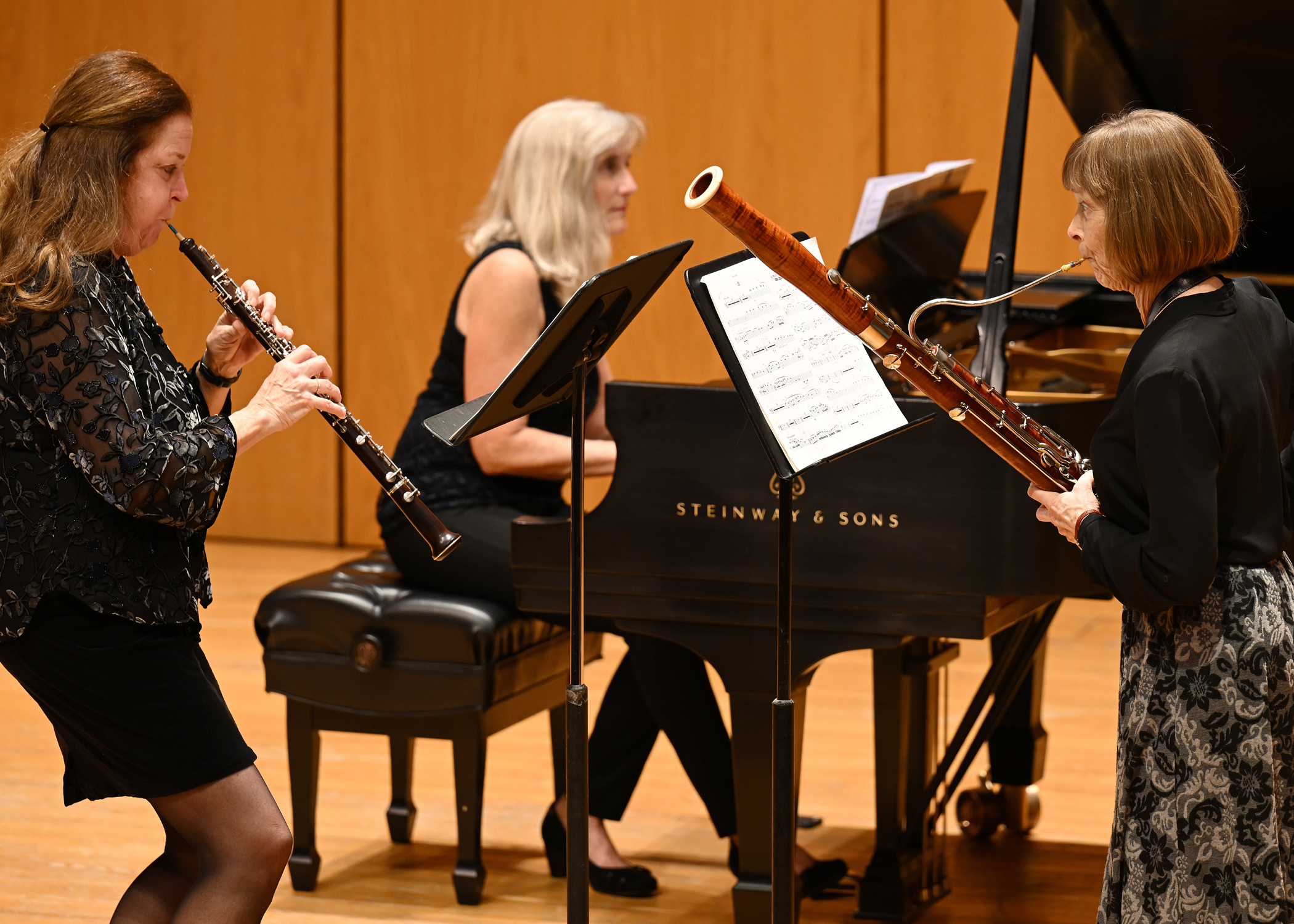 3 musicians on stage playing the piano and wind instruments